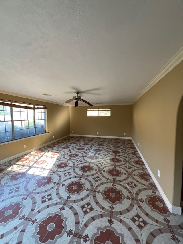 spare room with ceiling fan, a healthy amount of sunlight, and ornamental molding