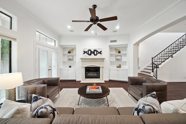 living room with crown molding, dark wood-type flooring, and built in features