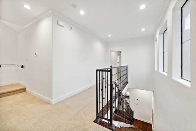 hallway featuring crown molding and light colored carpet