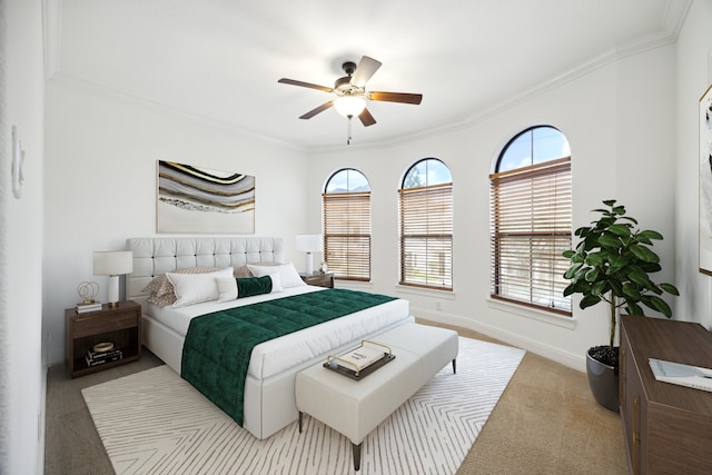 carpeted bedroom with ceiling fan and crown molding