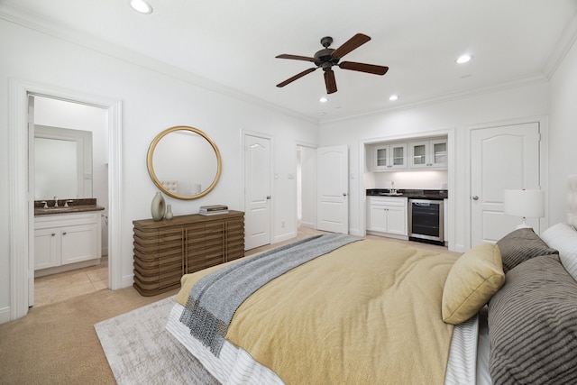 carpeted bedroom with sink, crown molding, ensuite bath, ceiling fan, and beverage cooler