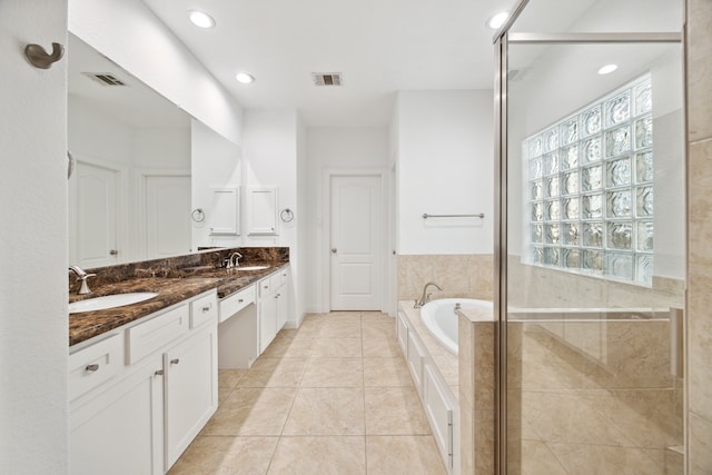 bathroom featuring plus walk in shower, tile patterned flooring, and vanity