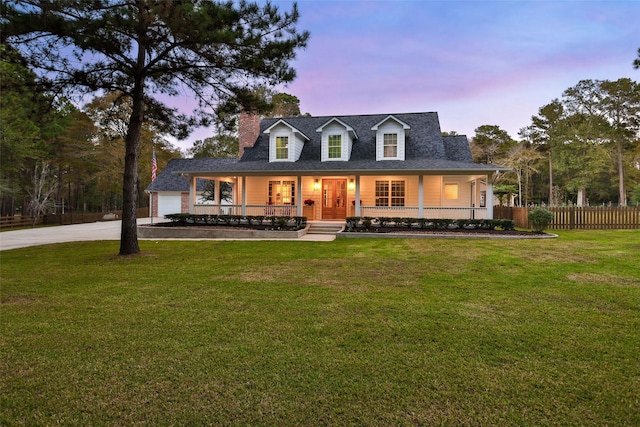 view of front of property with a porch, a garage, and a yard