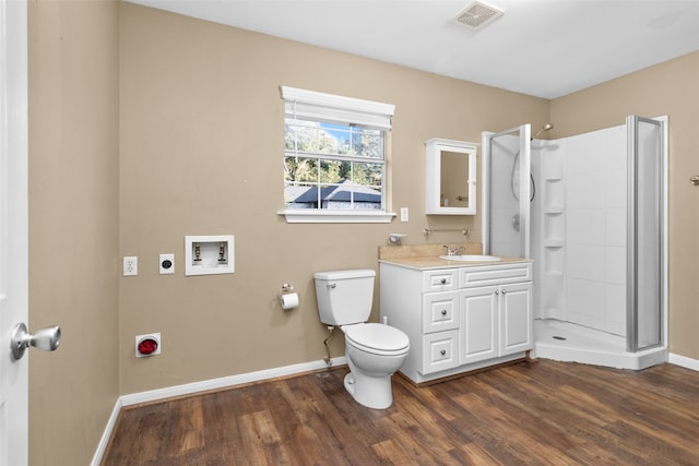 bathroom with hardwood / wood-style floors, vanity, toilet, and a shower