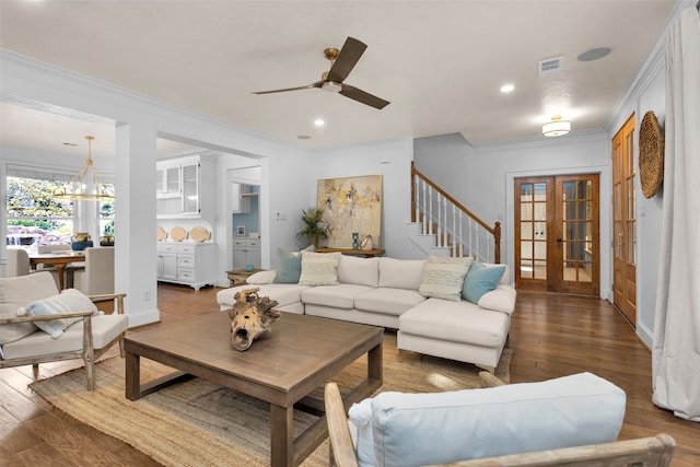 living room with ceiling fan with notable chandelier, dark hardwood / wood-style flooring, ornamental molding, and french doors