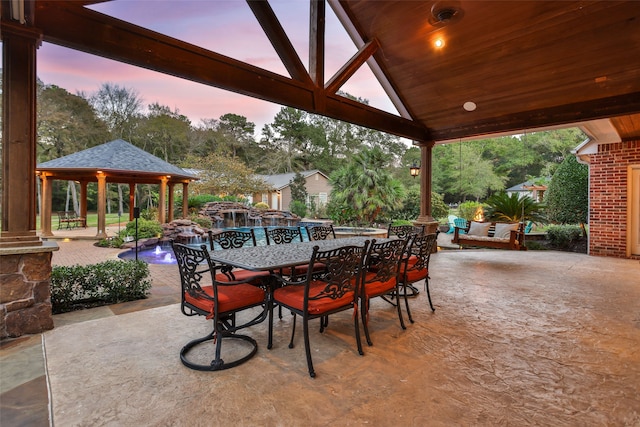 patio terrace at dusk featuring outdoor lounge area and a gazebo