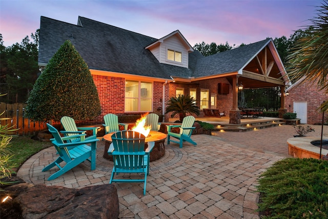 patio terrace at dusk featuring a fire pit