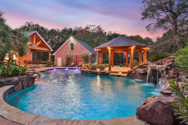 pool at dusk with a gazebo and pool water feature