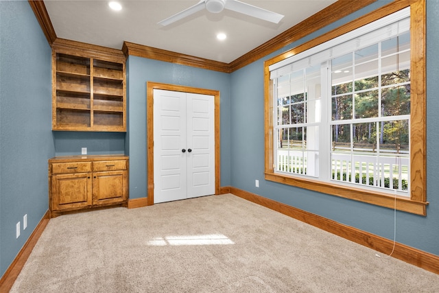 unfurnished bedroom featuring ceiling fan, crown molding, light carpet, and multiple windows