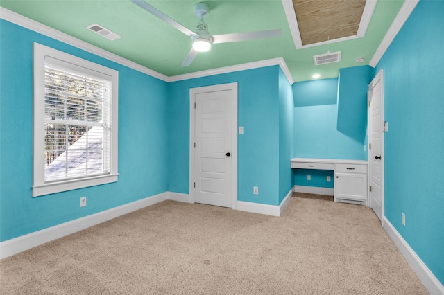 unfurnished bedroom with ceiling fan, crown molding, and light colored carpet