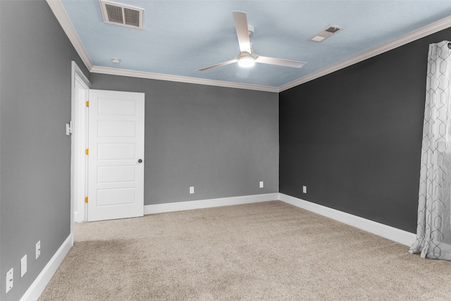 carpeted spare room featuring crown molding and ceiling fan