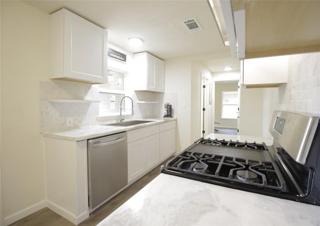 kitchen featuring white cabinets, sink, tasteful backsplash, dark hardwood / wood-style flooring, and stainless steel appliances