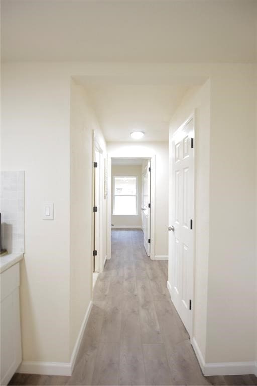 hallway with light hardwood / wood-style flooring