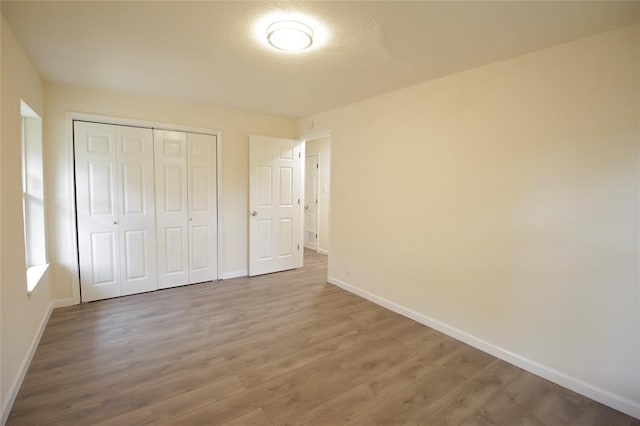 unfurnished bedroom with hardwood / wood-style flooring and a closet