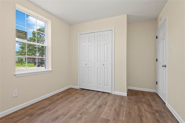 unfurnished bedroom featuring light hardwood / wood-style flooring and a closet