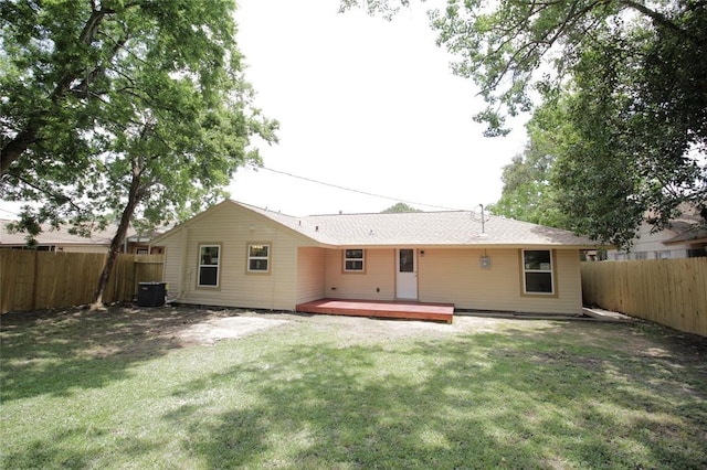 rear view of house featuring central AC unit, a wooden deck, and a lawn