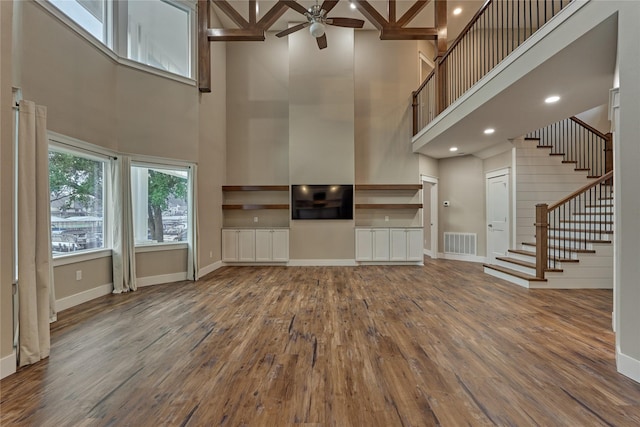 unfurnished living room with visible vents, baseboards, and wood finished floors