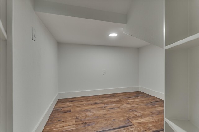 basement with recessed lighting, wood finished floors, and baseboards