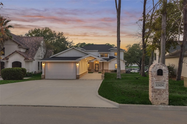 view of front of property with a front yard, an attached garage, driveway, and roof with shingles