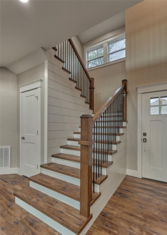 staircase featuring visible vents, baseboards, and wood finished floors