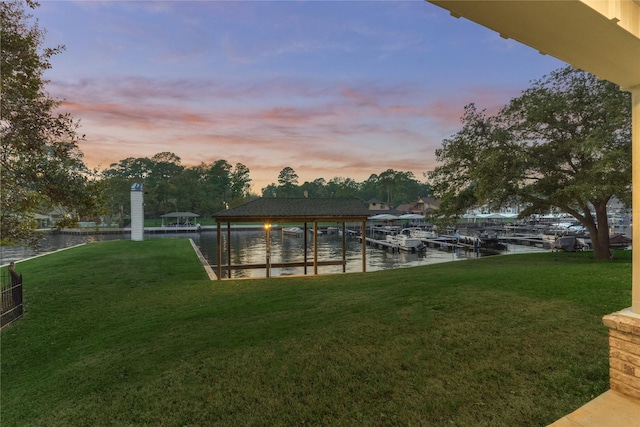 dock area with a lawn, a water view, and boat lift