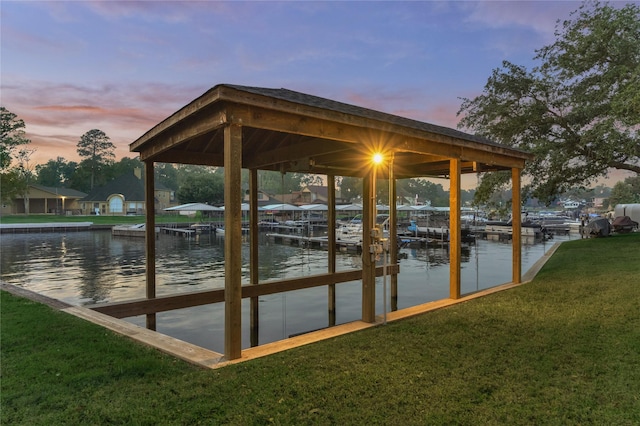 view of dock featuring a lawn, a water view, and boat lift