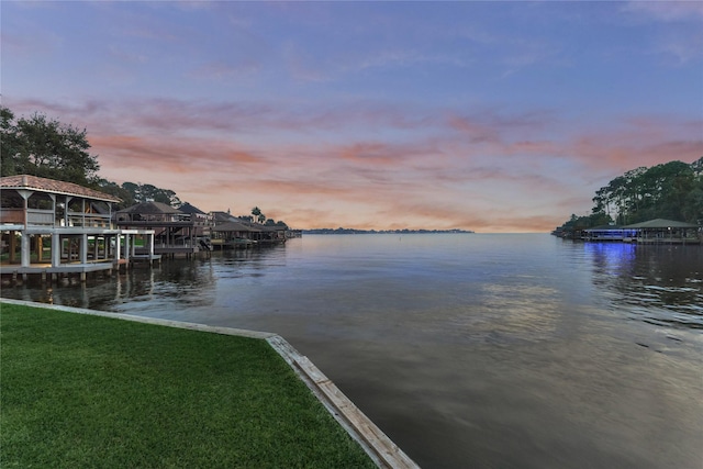 view of dock featuring a water view and a lawn