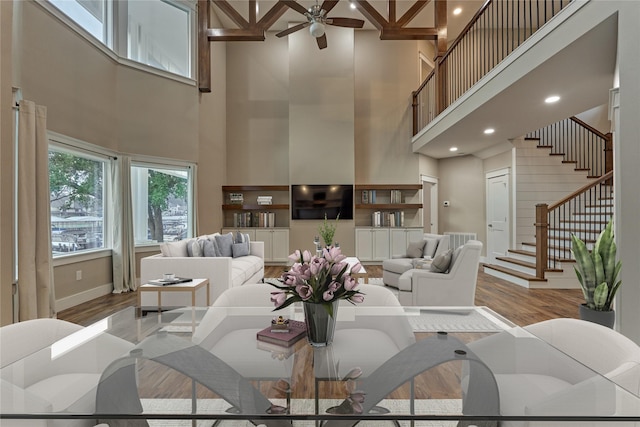 living room with baseboards, stairs, a ceiling fan, and wood finished floors