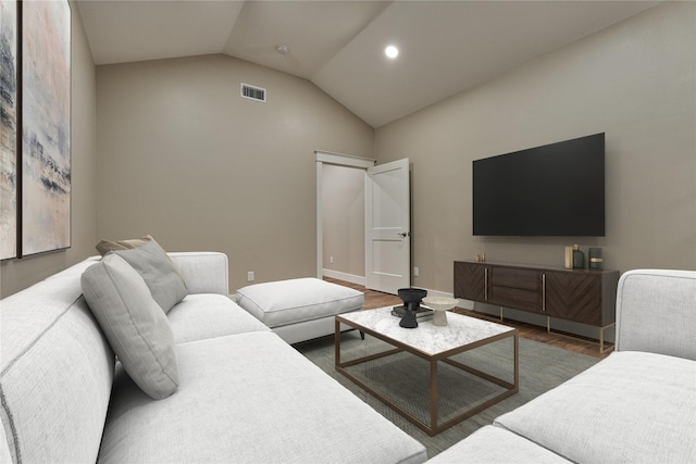 living room with vaulted ceiling, wood finished floors, visible vents, and baseboards