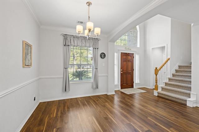 foyer with dark wood-type flooring, an inviting chandelier, a healthy amount of sunlight, and crown molding