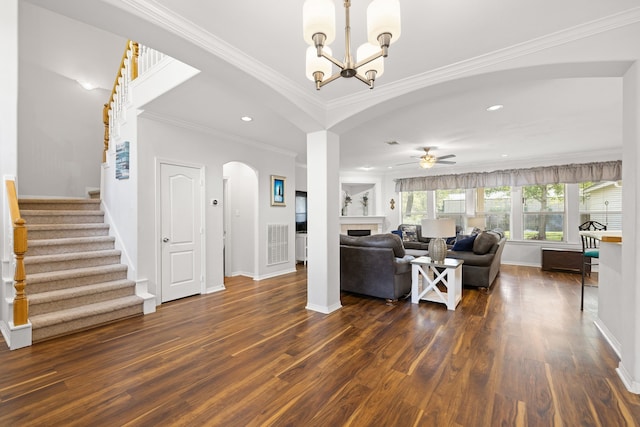 living room with ornamental molding, ceiling fan with notable chandelier, and dark wood-type flooring