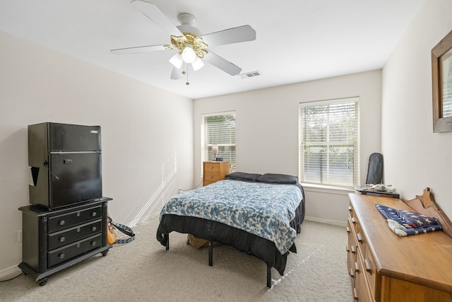 bedroom with ceiling fan and light carpet