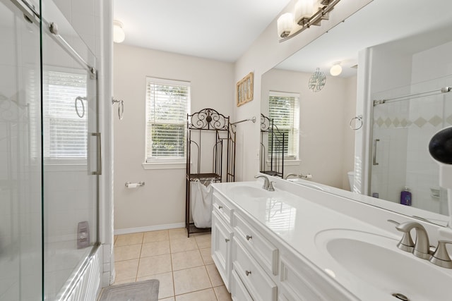 bathroom featuring tile patterned flooring, vanity, and bath / shower combo with glass door