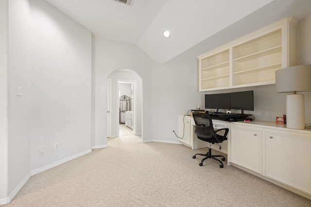 carpeted office space with built in desk and lofted ceiling