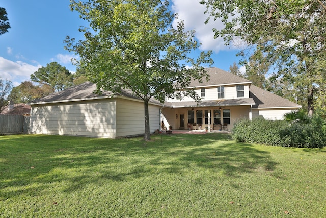 rear view of property featuring a lawn and a patio area