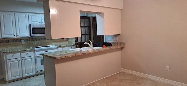 kitchen with white cabinets, white range, kitchen peninsula, and sink