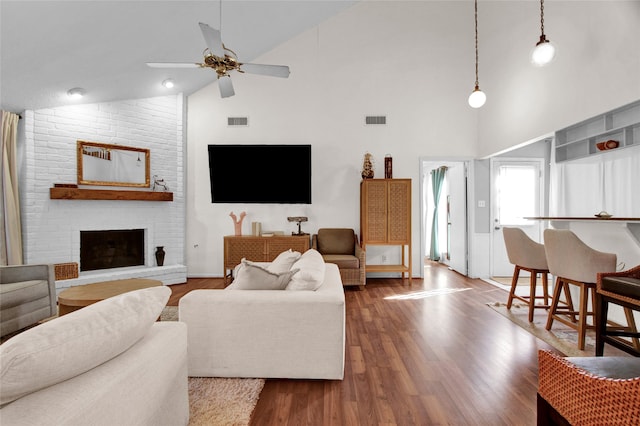 living room with ceiling fan, a fireplace, high vaulted ceiling, and dark wood-type flooring