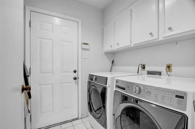 washroom with washer and dryer, cabinets, and light tile patterned floors