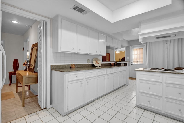 kitchen featuring white cabinets, white gas stovetop, extractor fan, and light tile patterned floors