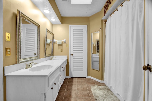 bathroom featuring tile patterned flooring, a textured ceiling, and vanity