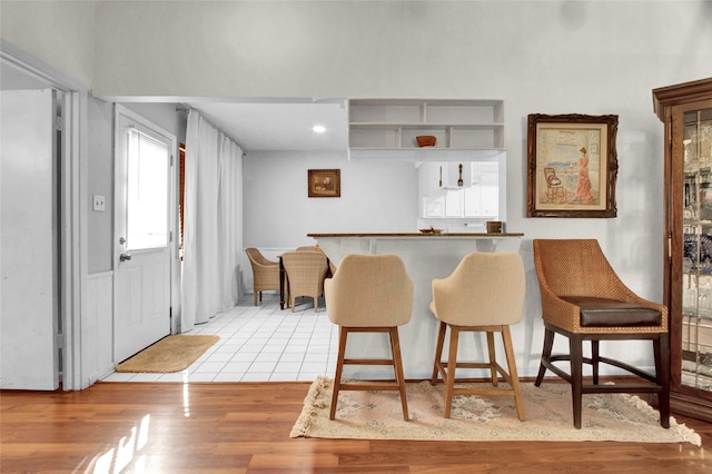 kitchen with a kitchen bar and light wood-type flooring