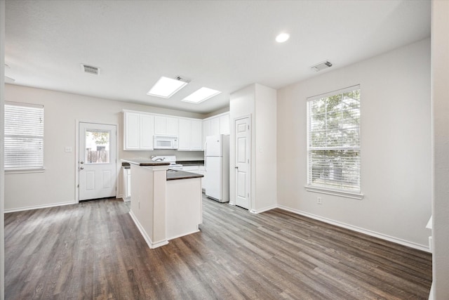 kitchen featuring dark hardwood / wood-style flooring, white cabinets, and white appliances