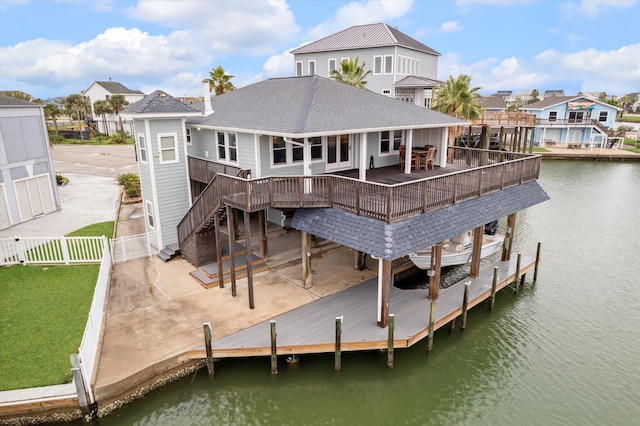 rear view of property featuring a deck with water view and a patio area