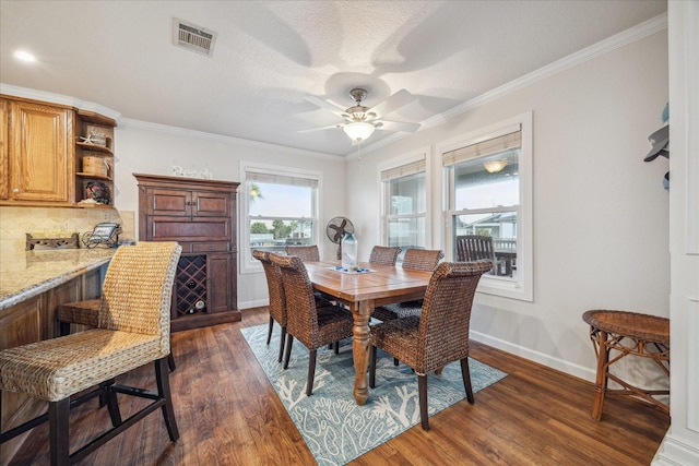 dining area with ceiling fan, dark hardwood / wood-style flooring, and crown molding