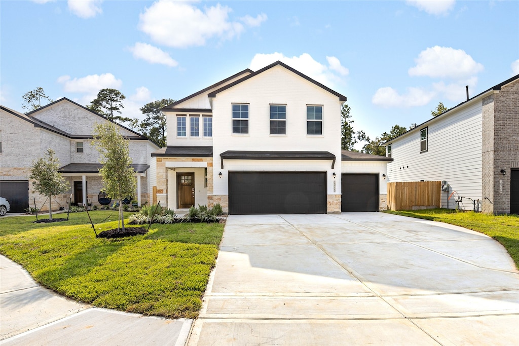 view of property with a garage and a front lawn