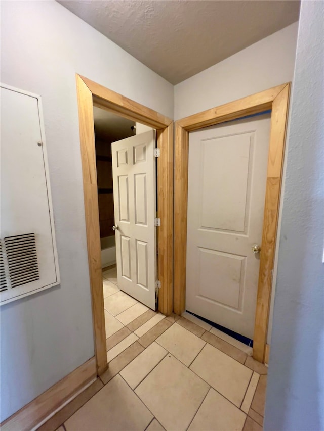 hall featuring light tile patterned floors