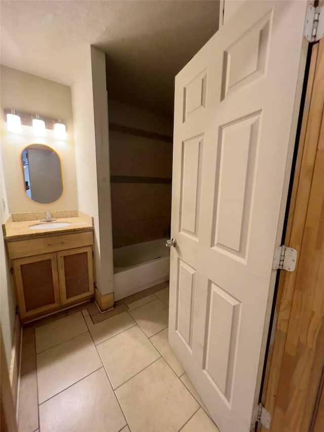 bathroom featuring tile patterned flooring, vanity, and a bath