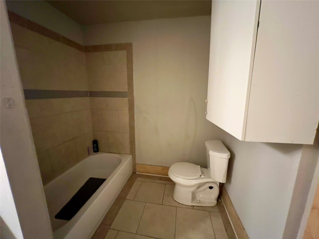 bathroom featuring tile patterned flooring, a bath, and toilet