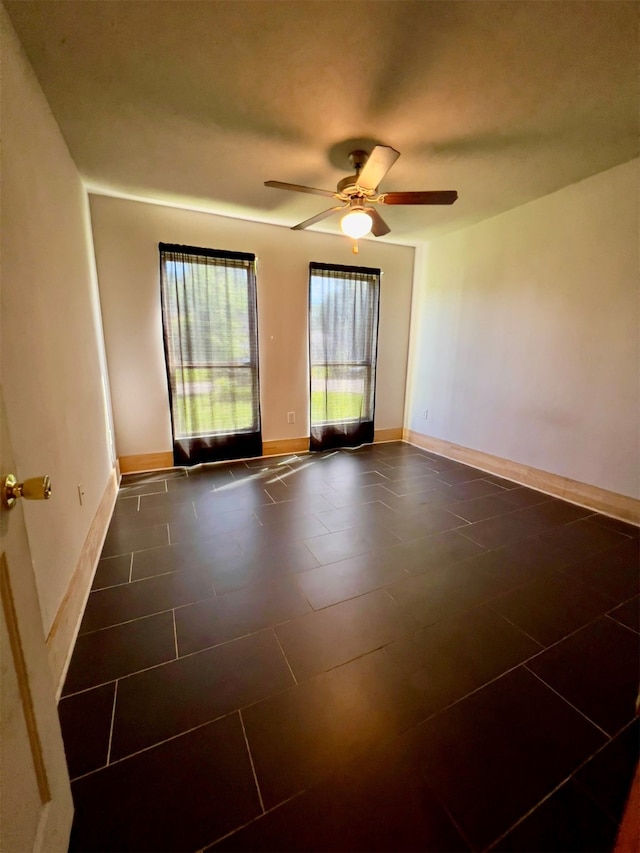 tiled empty room featuring ceiling fan