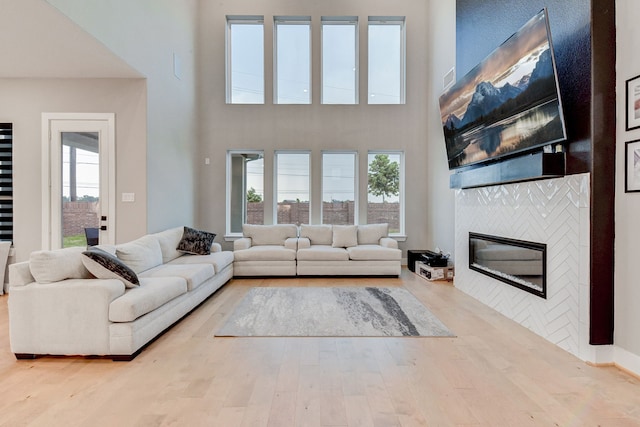 living room with a fireplace, a high ceiling, and hardwood / wood-style flooring